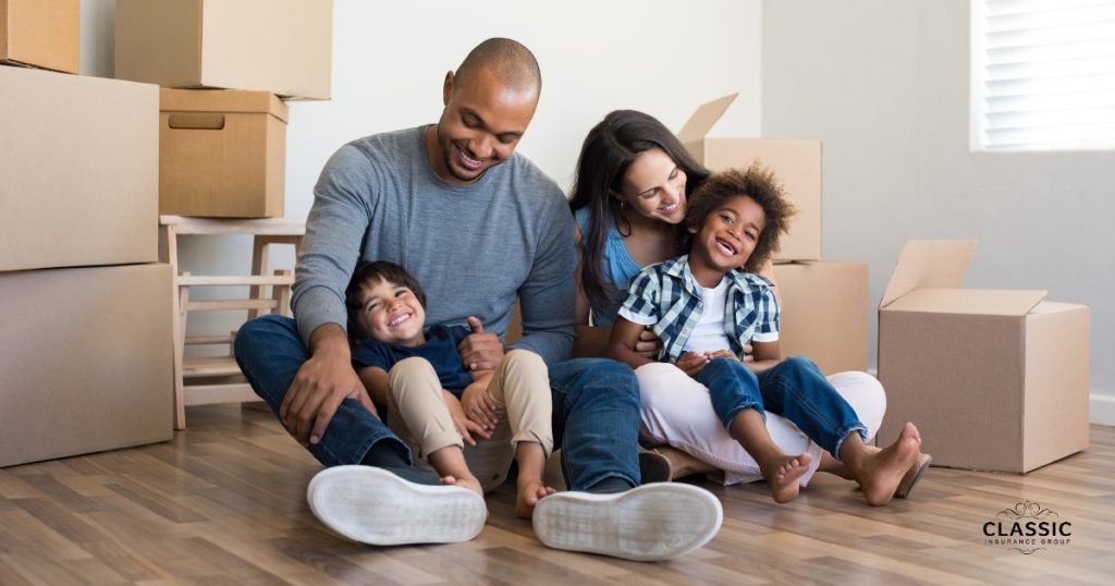 Young African-American family sitting in the floor of their new home with packing boxes.